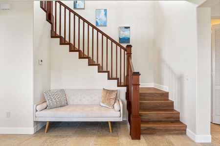Elegant staircase with a cozy seating nook under the stairs.