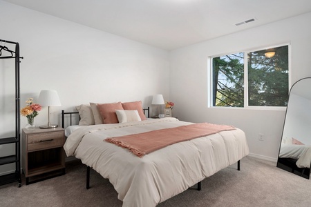 This calming primary bedroom with a king-sized bed provides a restful haven after days of lake adventures—complete with plush bedding and natural textures.