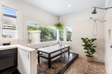 Soak in garden serenity—this spa-style tub is framed by greenery and natural light, offering the perfect way to unwind.