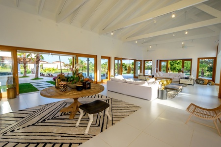 Gather in the living area with open concept floor plan, high, vaulted ceiling and large glass window walls.