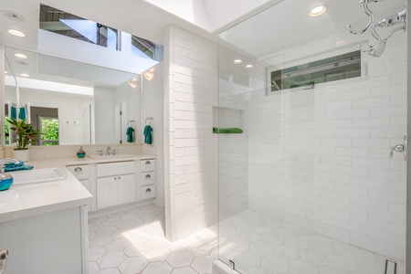 Ensuite in white finish with a walk-in shower and wide vanity space.
