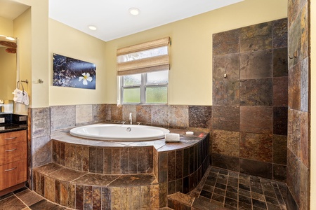 Luxurious bathroom with a spacious soaking tub and slate accents for ultimate relaxation.