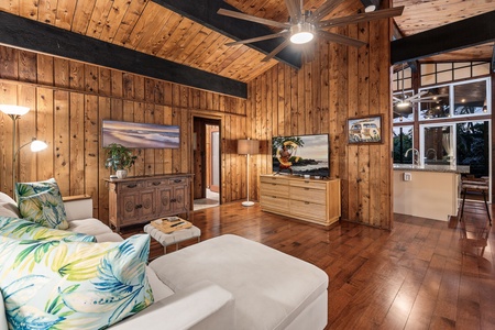 Unwind in your pleasant living room where warm wood walls meet tropical accents, creating the perfect retreat for cozy evenings.