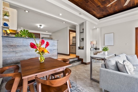 Dining area with seating for four and fresh floral centerpiece, perfect for meals.