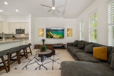 The cozy living room invites you to unwind with stylish décor, ample seating, and a large smart TV.