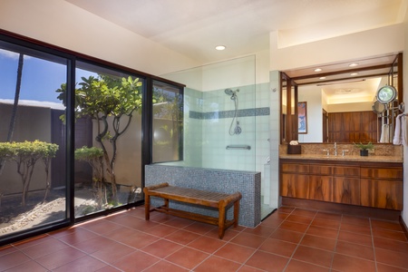 Tropical garden views and easy lanai access turn this bathroom space into a calming open-air spa experience.