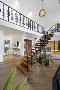 Elegant wood staircase leads to the lofted suite, blending contemporary style with architectural charm.