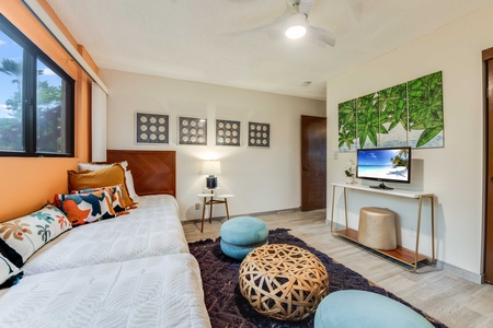 Relax in the second bedroom with a garden view, adjacent bathroom access, and thoughtful island-inspired decor.