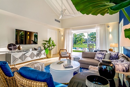 Second living space with ample seating, a large TV and view of the outdoors.