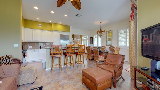 The open floor plan includes seating in the kitchen bar area and living and dining areas.