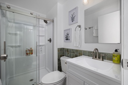 Second bathroom includes a sleek glass-enclosed shower and modern vanity for added comfort.