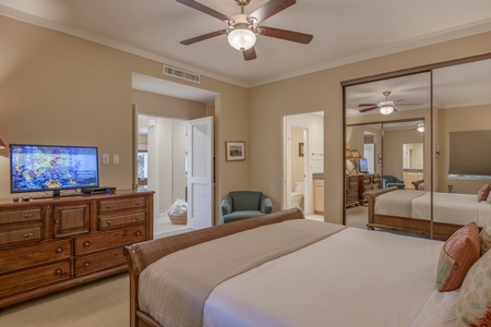 Primary bedroom with king bed and tropical-themed décor creates a cozy, restful retreat.