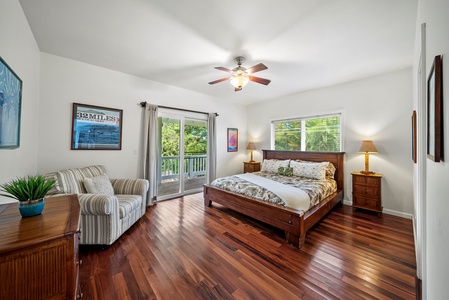 Primary bedroom with Cal king bed, private lanai access, and lush surroundings.