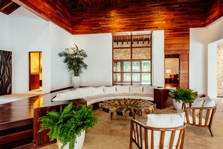 Relax in the cozy and stylish living area with elegant wooden accents and lush greenery.