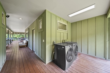 Convenient outdoor laundry area with full-size washer and dryer, tucked under covered breezeway.