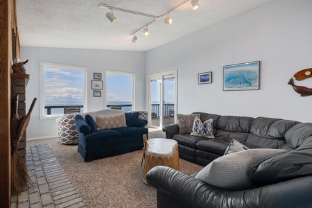 The West-facing living room has a cozy space to unwind with comfortable seating and a spectacular view of the water.
