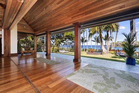 Your covered lanai opens to stunning ocean views framed by swaying palms, where warm trade winds flow through this elegant tropical sanctuary.