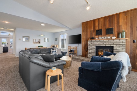 Gather and relax by the fireplace with plush sofas and TV.
