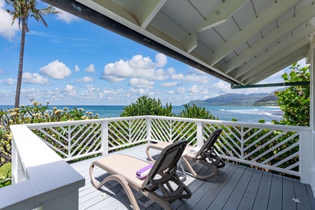 Your private balcony offers breathtaking ocean views where you can unwind on comfortable loungers while watching waves roll toward distant mountains.