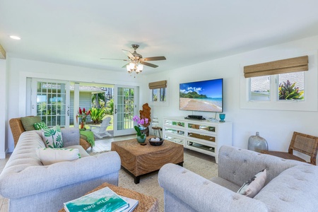 The bright living area opens seamlessly to the lanai, inviting cooling trade winds and creating an effortless indoor-outdoor living experience.