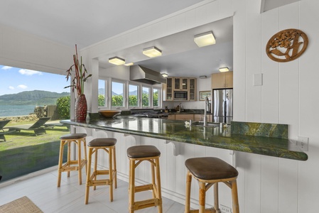 Your gourmet kitchen features granite countertops and stunning ocean views, perfect for preparing meals while soaking in the tropical paradise.