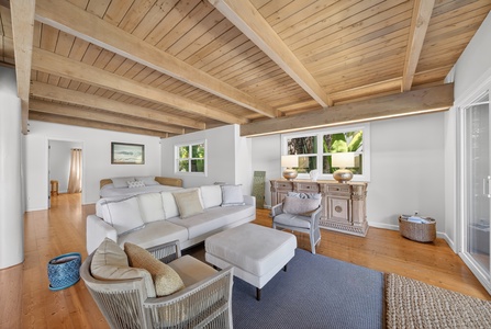 Settle into your bright, airy living space with stunning vaulted ceilings and warm wood floors. Natural light pours through large windows as you relax on plush seating surrounded by coastal charm.