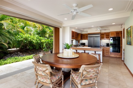 Your open-concept kitchen flows seamlessly to lush tropical gardens, creating the perfect indoor-outdoor dining experience with cooling ceiling fans overhead.