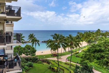 Tropical paradise unfolds before you - palm trees frame pristine beach waters from your oceanfront balcony in this stunning coastal resort setting.