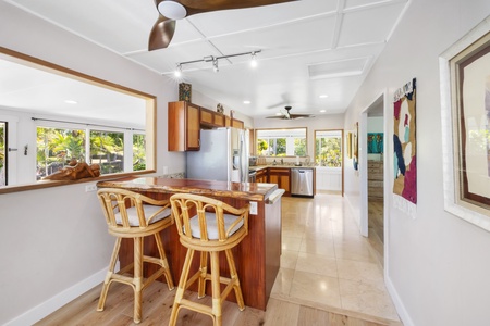 The bright kitchen features modern appliances, bar seating, and plenty of space for cooking while staying connected with the rest of the home.