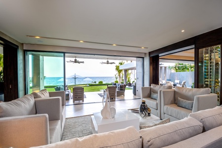 Spacious living room with plush seating, modern decor, and breathtaking ocean views.