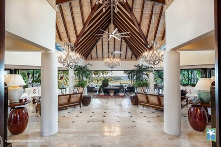 Elegant lobby, featuring high ceilings, chandeliers, and lush greenery.