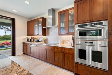 Rich wooden cabinets and stainless steel appliances.