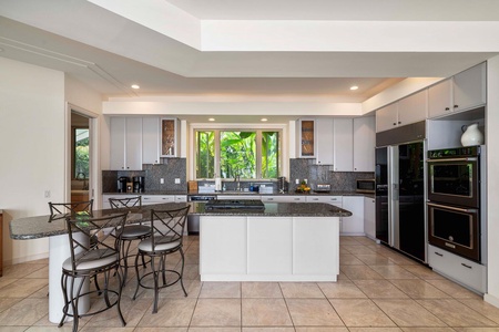 Large chef-ready kitchen with central island and stainless steel appliances.