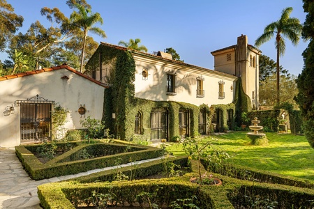 A timeless Mediterranean façade wrapped in ivy and framed by manicured grounds sets the stage for serene, Old World elegance.