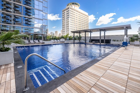 Relax by the sleek outdoor shared pool with city views.