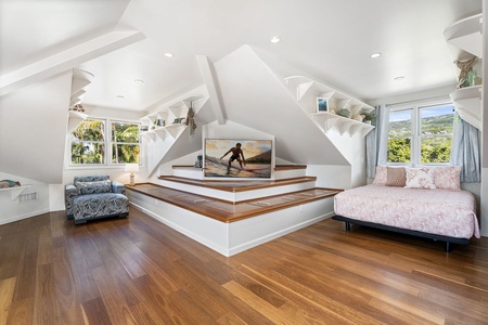 Your loft bedroom offers a cozy Queen beds and entertainment center with tropical views through bright windows.