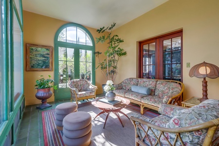 Immerse yourself in the sunroom, where plush seating and warm natural light blend perfectly with captivating outdoor views for a truly serene retreat.