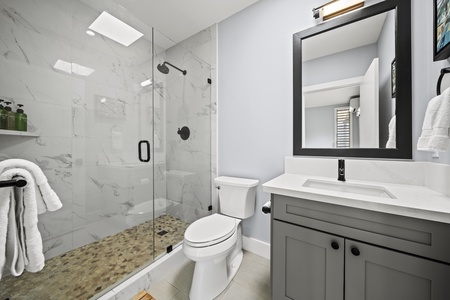 Full bathroom in Bedroom 3 with a walk-in shower, granite vanity, and custom tilework.