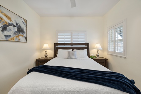 Third guest bedroom features a queen-size bed, ambient lighting, and shuttered windows for privacy.