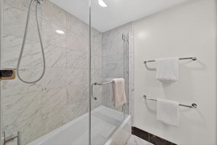 Refresh after beach days in the marble shower with fresh towels close at hand.