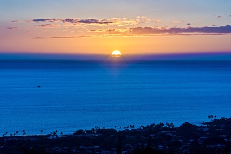 Breathtaking ocean sunset creates a spectacular backdrop, painting the sky in brilliant oranges and purples over the endless blue waters.