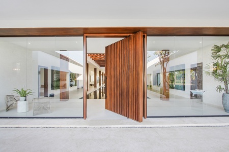 Enter through large wooden doors into a bright and modern space with lots of natural light.