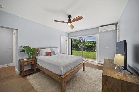 Third bedroom offers queen bed, dresser, and lush garden outlook.