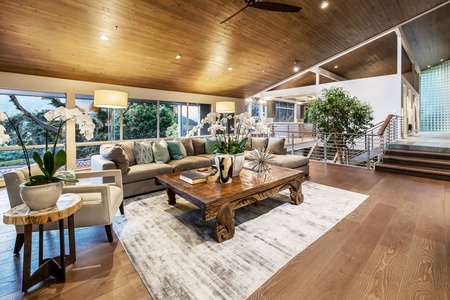Gather in the main living area where custom wood ceilings meet floor-to-ceiling windows and natural light.