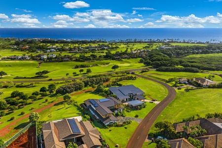 Aerial view showcases the property's prime location amid lush golf courses with stunning ocean backdrop and tropical landscape.