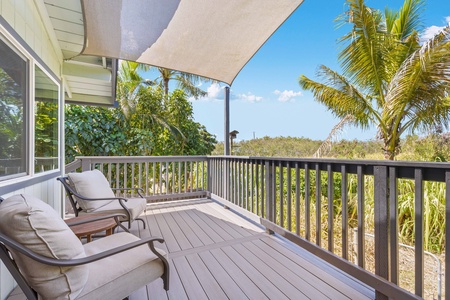 Relax on the shaded lanai with cozy lounge chairs and a peek at the tropical treetops.