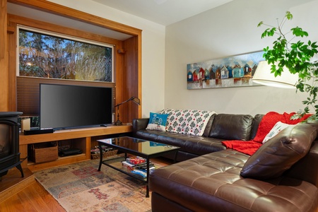 Living room with leather seating and holiday decor, ideal for relaxing by the fire.