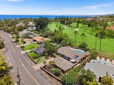 The neighborhood rolls down toward the water past the golf fairways.
