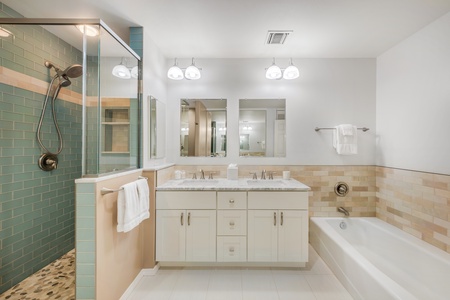 Refreshing and refined, this ensuite features a sleek walk-in shower, spacious countertops, and tropical-inspired accents.