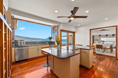 Stunning oceanfront living room where soaring ceilings and panoramic windows frame endless sea views while you relax by the stone fireplace.
